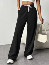 Black wide leg pants with a white drawstring waistband made from soft fabric for comfortable casual wear