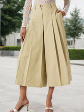 Beige high-waisted pleated wide-leg cropped pants with button closure in lightweight fabric and cropped length