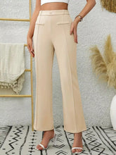 Beige high waist flare pants with a tailored fit and front flap pockets in a wide-leg design