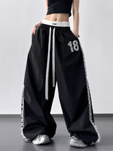 Black lace detail drawstring wide leg pants with white lace trim and silver 18 embroidery on thigh