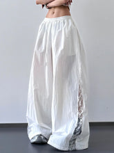 White wide-leg pants with elastic waist and sheer lace side panels for stylish comfort and elegance