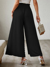 Black high-waisted tied slit wide leg pants with smooth flowing fabric showcasing elegant wide leg design
