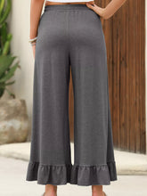 Gray ruffled wide leg pull on high waist pants with elastic waistband and ruffled hem with pockets