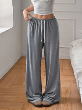Gray soft wide leg pants with a drawstring waist and white cord accents designed for comfortable lounging