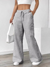 Striped wide leg pants in soft gray and white vertical stripes with elastic waist and drawstring for comfortable fit