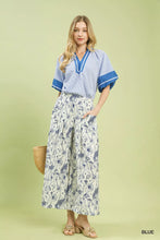 Blue and white striped short-sleeved blouse with v-neckline and blue trim paired with umgee floral print pants