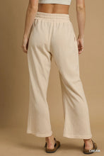 Cream-colored ribbed umgee wide leg pants with elastic waistband featuring comfortable drawstring design