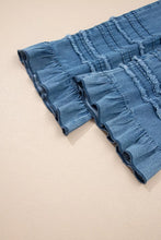 Blue chambray pants featuring wide leg design with ruffled hem and frayed detailing on denim fabric
