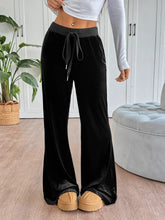 Black velvet wide-leg drawstring pants with contrasting gray drawstring waistband and easy care instructions