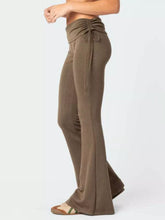 Olive green high-waisted flare pants made of polyester fabric with a drawstring waistband for comfortable fit