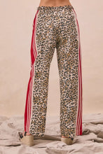 BiBi leopard print pants featuring bold red and white striped side panels with contrast and welt pockets