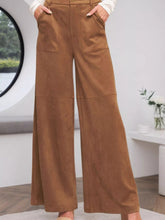 High-waisted brown suede wide-leg pants with front pockets and braided waistband detailing care instructions included