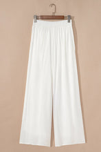 White high-waisted flowy wide leg pants with elastic drawstring waist and lightweight fabric for comfortable wear