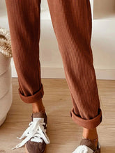 Casual corduroy drawstring waist pants in warm brown with vertical ribbed texture and rolled cuffs for adjustable comfort