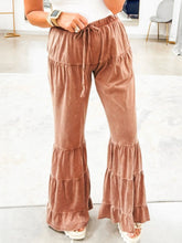 Rust-colored velvet drawstring flare ruffle pants featuring tiered ruffles at hem and elastic waistband