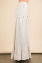A flowing off-white palazzo pants with palazzo elastic waist and tiered ruffles at the hem in very j design