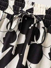 Plus size black and white abstract print pants with wide leg and drawstring waistband in geometric pattern