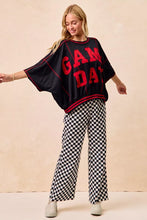 Black oversized sweatshirt with bold red game day lettering and trim paired with bibi gameday checkered printed pants