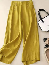 High-waisted mustard-yellow wide-leg pants with button detailing on the waistband for stylish comfort