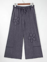 Dark gray terry knit wide leg pants with embroidered flower patch mineral washed details on the thighs