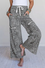 Animal print wide leg terry knit pants in leopard print with white drawstring waistband and cream pocket trim