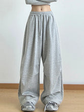 Gray heathered drawstring wide leg pants with elastic waistband and loose fit featuring care instructions tag visible
