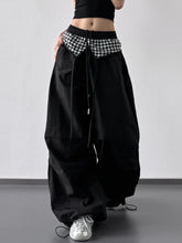 Wide leg pants in black with a contrasting black and white checkered waistband and drawstring ties