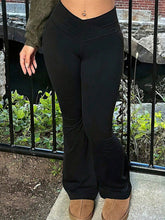 Black high-waisted flare pants in stretchy form-fitting fabric with subtle seam detailing for a sleek look