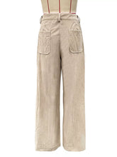 Beige wide leg corduroy pants featuring two front patch pockets and a belt looped at the waist