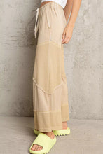 Beige pol elastic waistband wide leg pants with drawstring featuring layered textured and smooth fabric panels