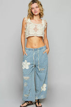A pair of light blue denim pol floral patch wide-leg pants with distressed details and crochet see thru patch
