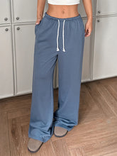 Blue wide leg pants with adjustable drawstring waist and relaxed fit made from soft comfortable fabric