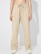 Beige drawstring wide leg pants with a relaxed straight-leg cut made from soft fabric for comfortable wear