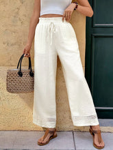 White wide leg pants with drawstring waist, delicate lace trim hem, and pockets for a perfect fit wide-leg pants look