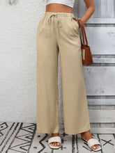 Beige drawstring high waist wide leg pants with a relaxed fit and adjustable waistband for casual comfort