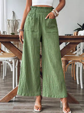Green textured high-waisted wide leg pants with elastic waistband and front pockets for comfortable wear
