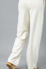 Cream-colored umgee high waisted wide-leg pants with soft flowing fabric and subtle side seam detailing