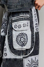 A patchwork denim skirt with black and white floral embroidery on front pockets paired with soft cotton jogger pants