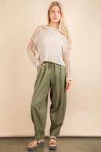 A woman wears olive green solid barrel comfy woven pants paired with a beige open-knit long sleeve sweater
