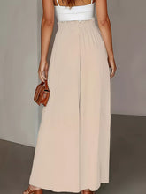 Beige high waist wide leg pants with a gathered waistband and flowing fabric for elegant wide leg style