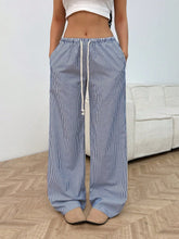 Drawstring striped wide leg pants in blue and white vertical stripes with elastic waistband and matching drawstring
