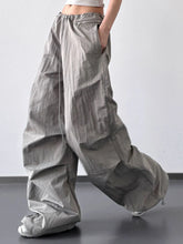 Wide-leg gray cargo pants with a drawstring wide leg waist and multiple pockets in durable fabric