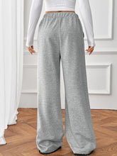 Gray heathered wide-leg pants with ribbed elastic waistband and black zigzag trim, machine wash care instructions