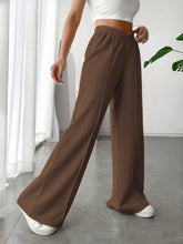 Brown wide leg high waist pants with elastic waistband made from smooth flowing fabric for comfortable wear