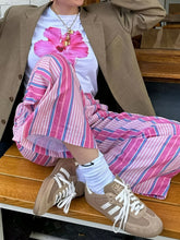 Tan suede adidas samba sneakers with white laces complementing striped wide leg drawstring pants style