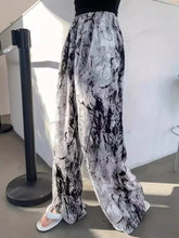 Abstract print wide leg pants in black and white marble pattern featuring a flowy fabric and stylish design