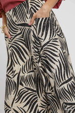 Black and cream umgee culotte pants featuring a bold palm leaf print and wide-leg silhouette