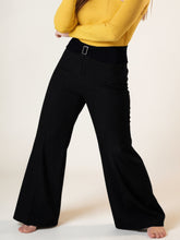 Plus size high-waisted flare pants in black wide-leg design with silver-toned belt buckle for stylish comfort