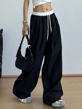 Black wide leg drawstring casual pants with white elastic waistband and matching leg drawstring for comfortable wear