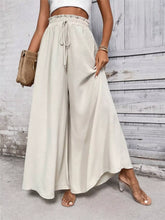 Beige high-waisted wide leg drawstring waist casual pants made of soft flowing fabric for comfortable wear